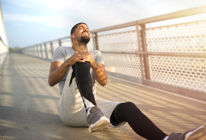 Sportsman having knee injury problem during running training.